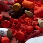 Tray of broken red Unison Colour pastels.