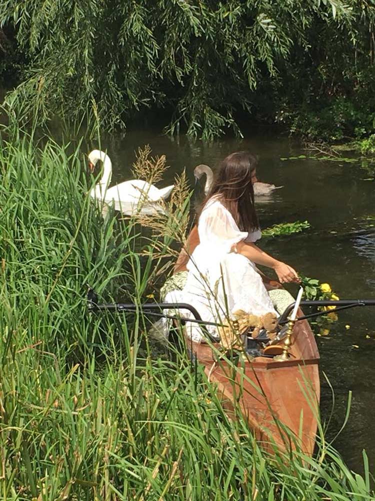 Women in a rowing boat, during the reenactment of the original painting 'Lady of Shalott'.