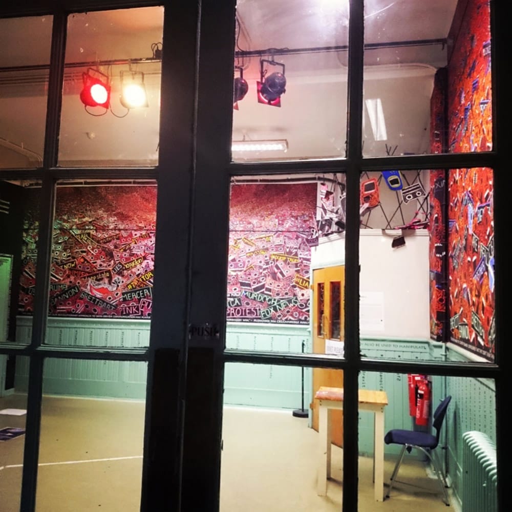 Looking in through a paned window, into the exhibition.