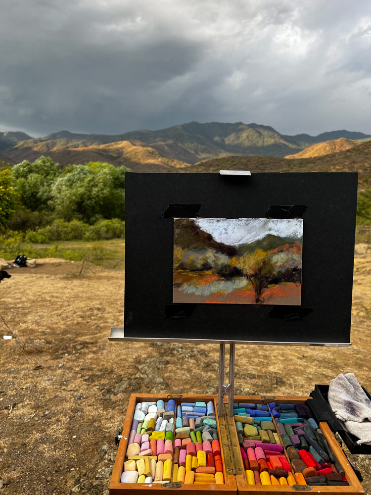 Easel with painting, working outdoors.