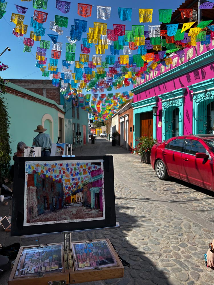 Suburban Mexican street, with bright colour houses and flags stretched across the street.