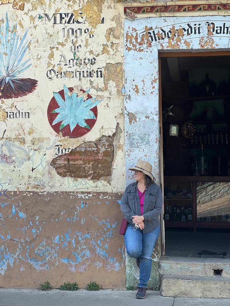 Neva Smoll leaning against a large rustic doorway.