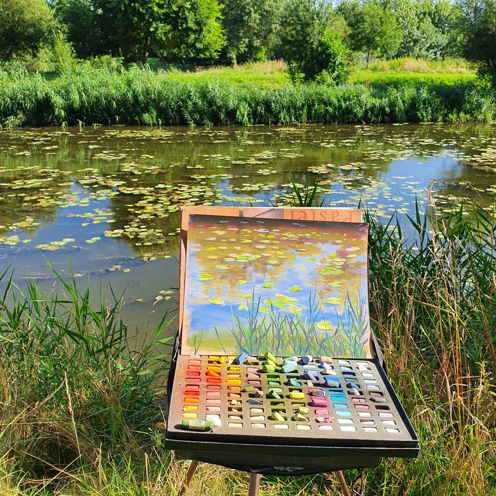 Cindy's painting on the banks of a river.