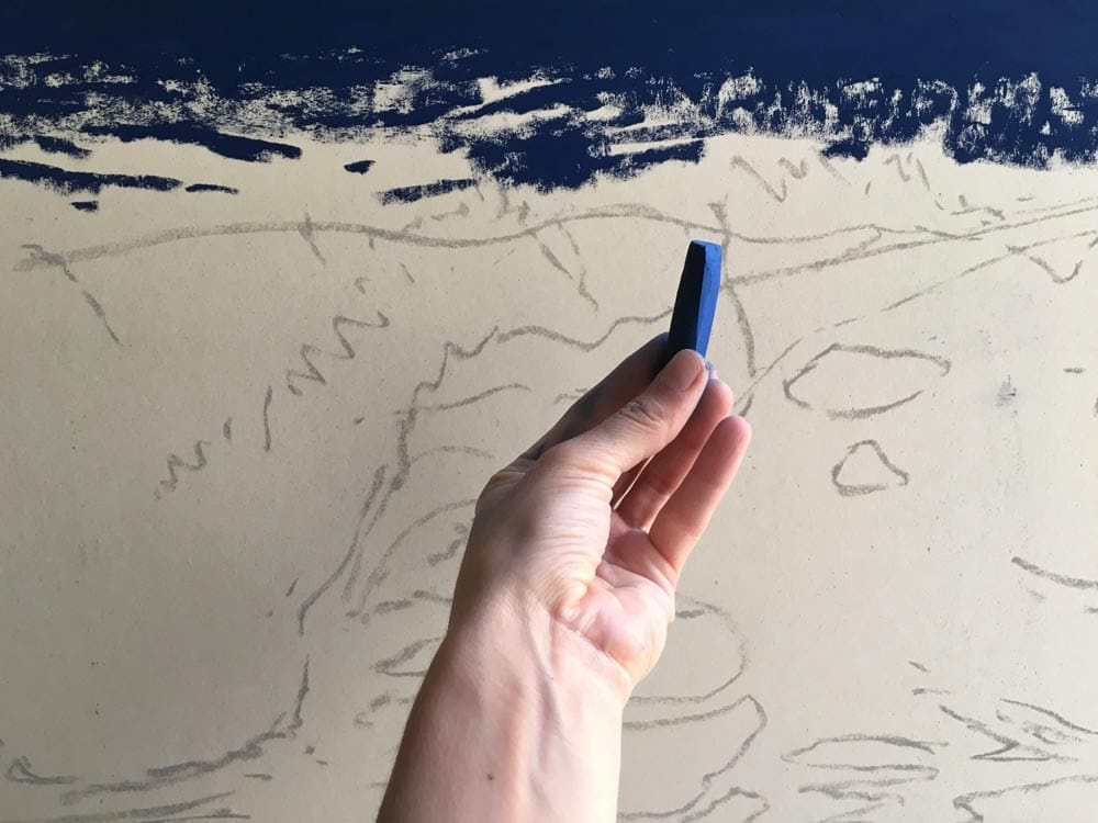 Elena selecting one of her deep blue pastel sticks.
