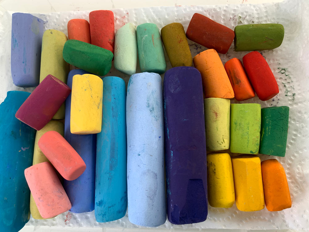 Colourful pastels laid out on tissue paper.
