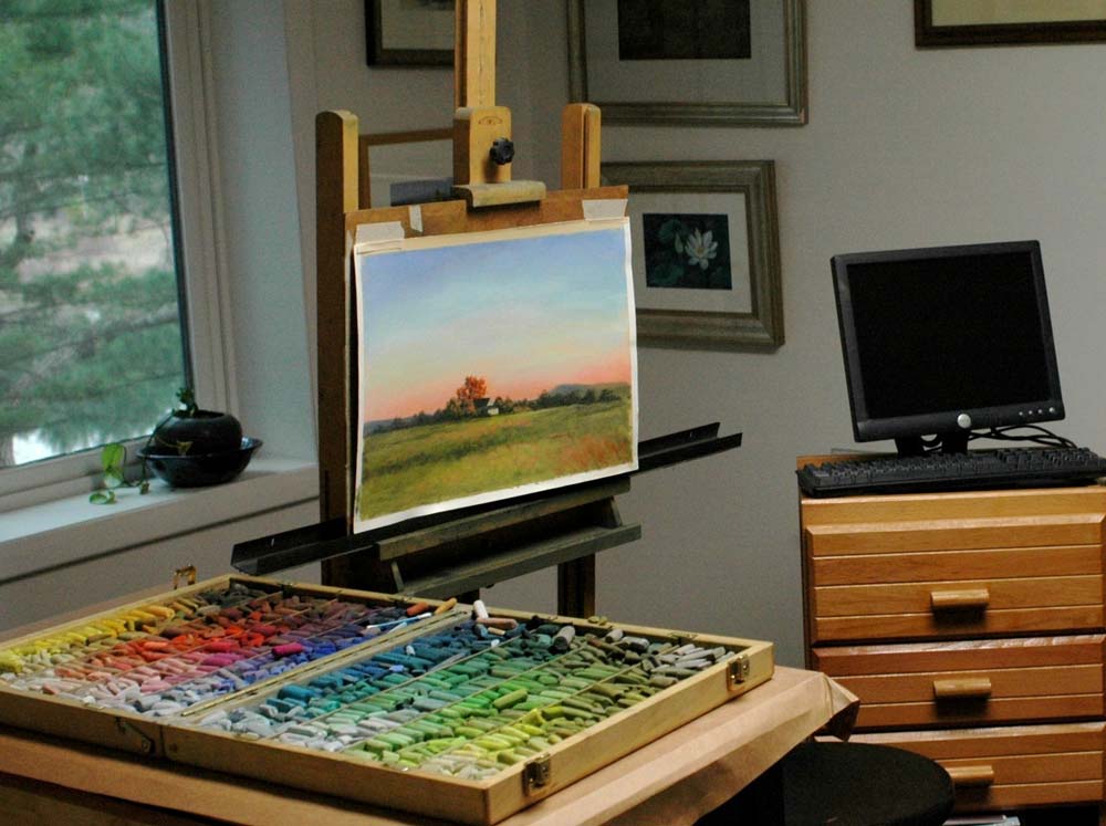 In Susan's home studio with easel and large selection of colourful. pastels.