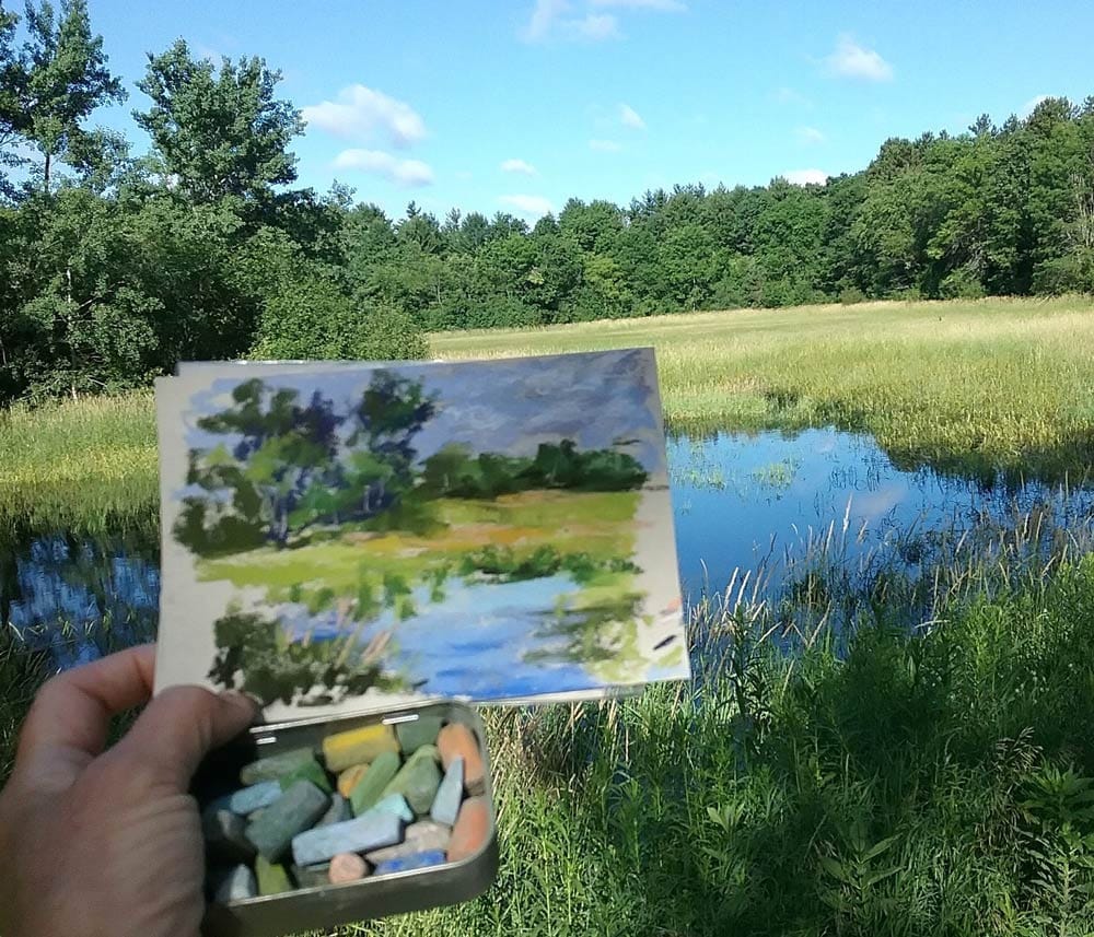 Susan's small plein air set up comprising of a small sketchbook and a tin of pastels.