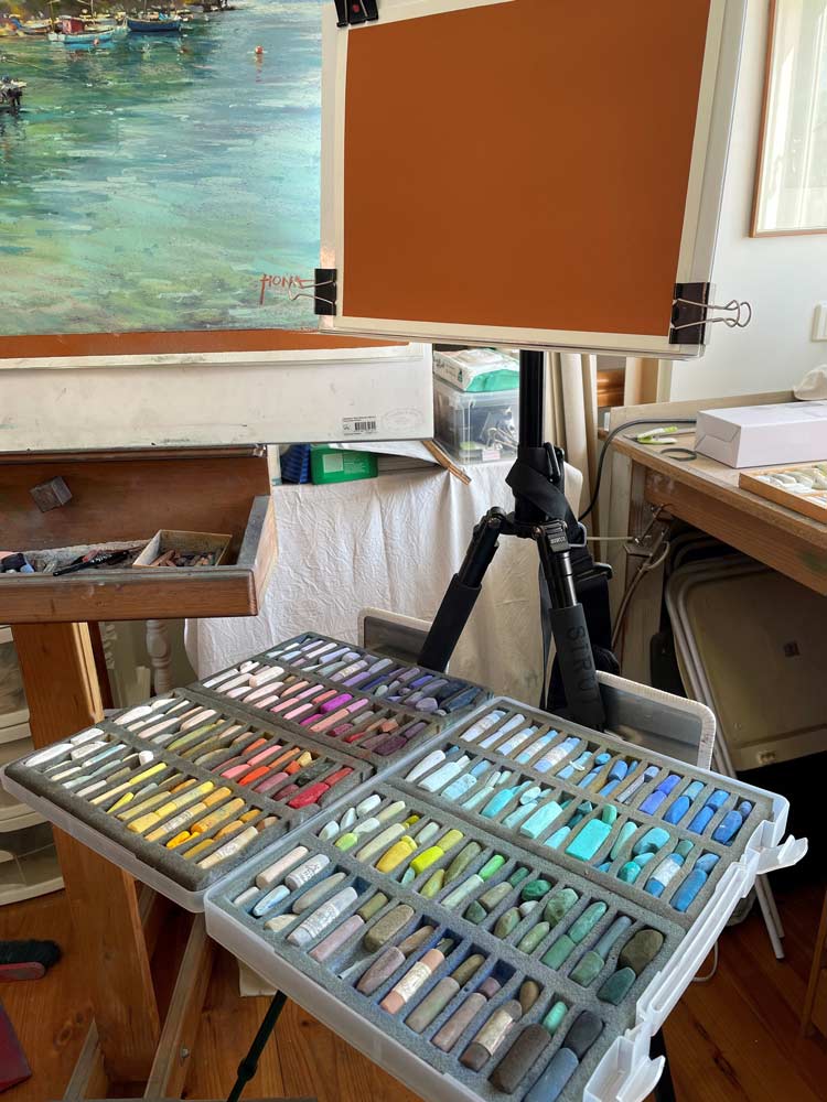 Regina&#039;s large set of pastel in front of an easel.