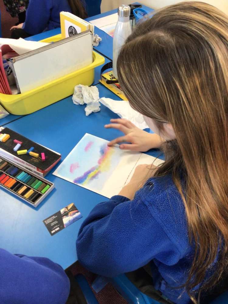 School pupil painting with pastels.