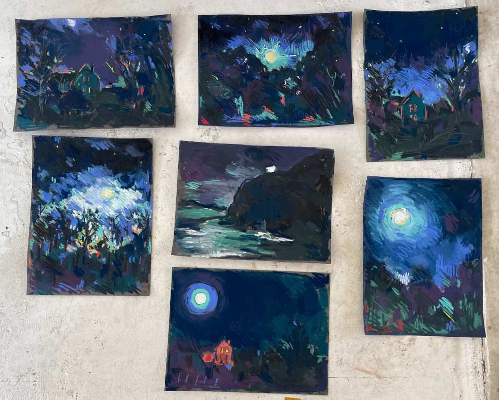 Amy Shuckburgh's dark sky soft pastel paintings laid out together before framing.