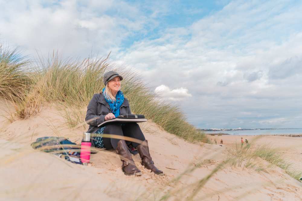 Nina Squire paints em plein air at the beach.