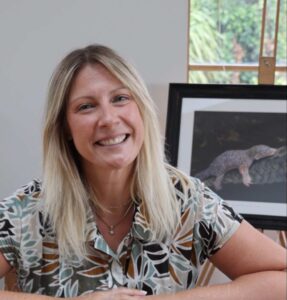 Profile photo of Meral Altilar, sitting in her studio in front of one of her works.