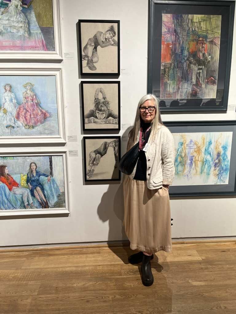 Michele Ashby stands next to her paintings.