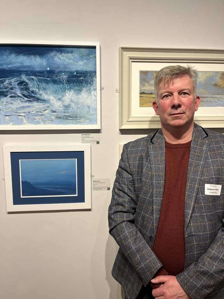 Stephen Fuller standing next to his painting 'After the Lifeguards Leave'.